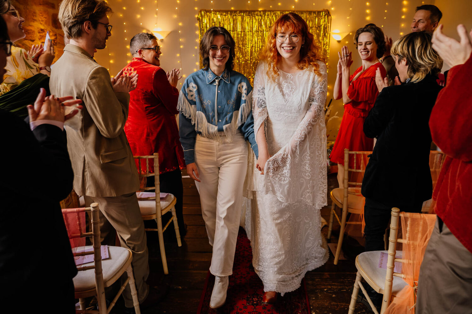Couple exit ceremony with guests clapping