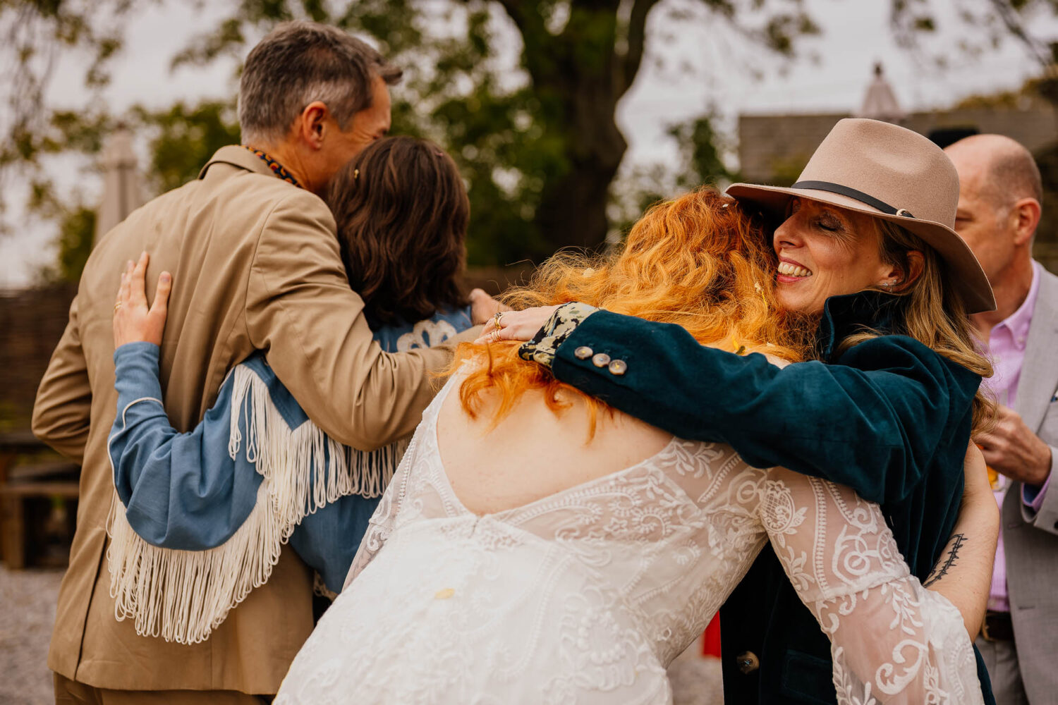 Guests in cowboy hats hugging bride