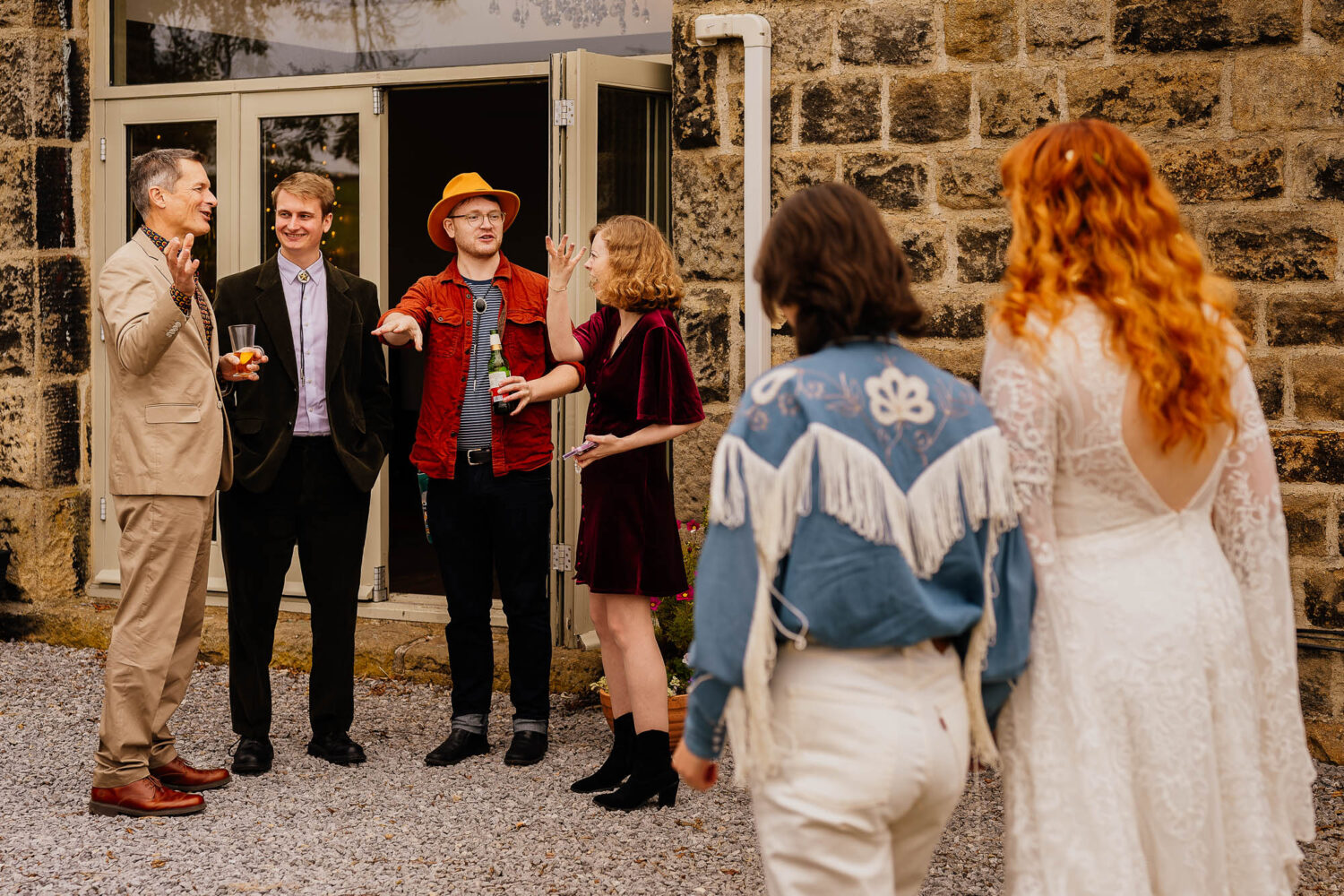 Wedding guests gesturing with couple approaching in the foreground