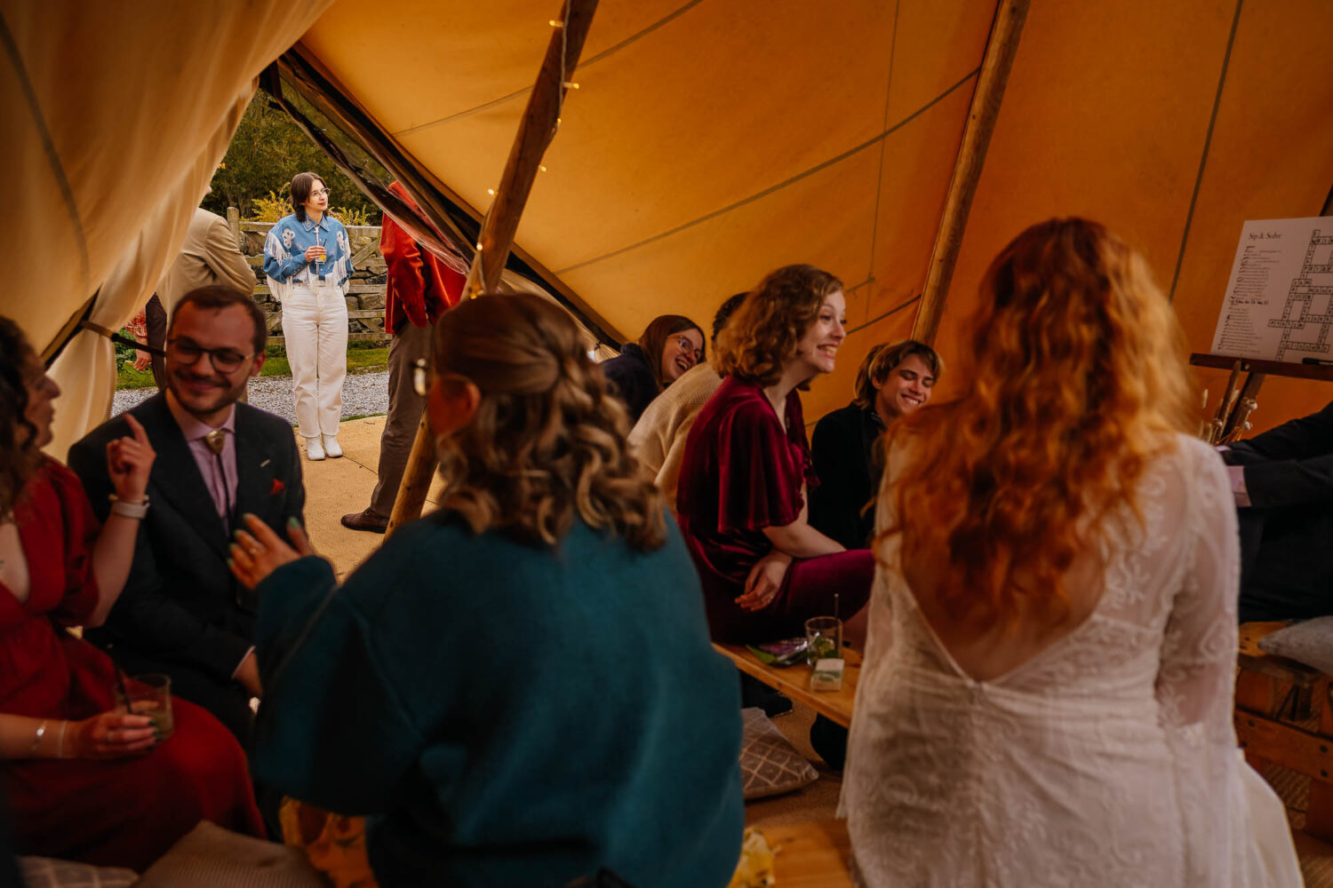 Couple talking to different friend groups inside and outside a tipi