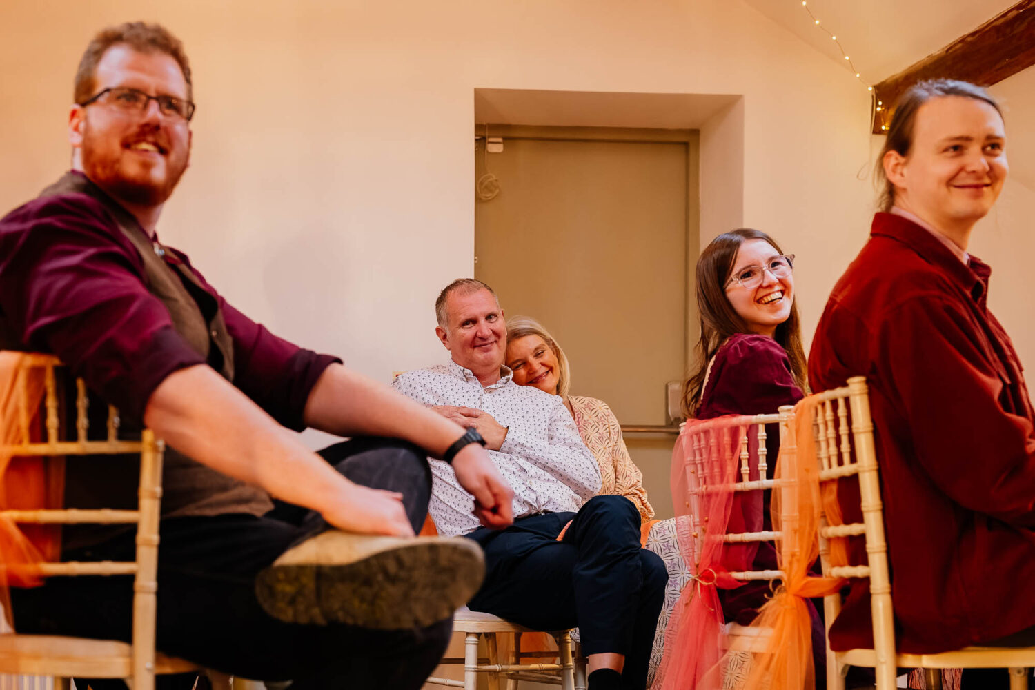 Guests watching wedding speeches with smiles on their faces