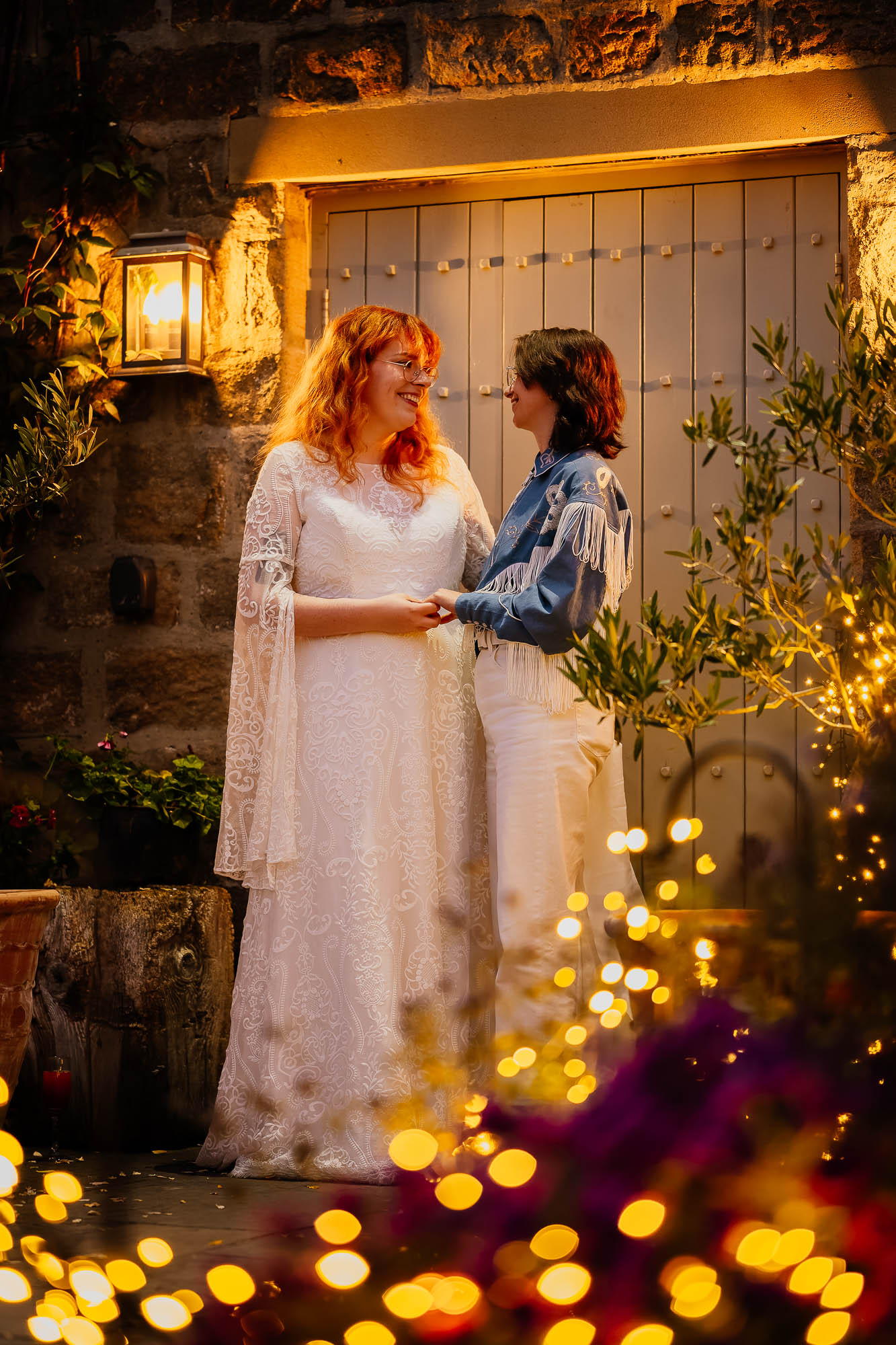 Couple holding hands in front of Chilli Barn with fairy lights in the foreground