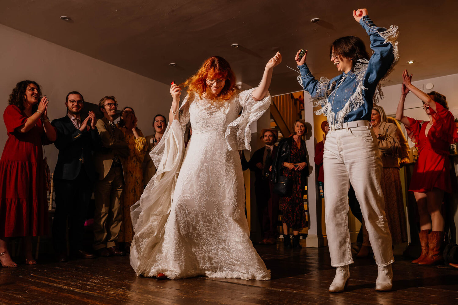 A couple dancing with guests around them cheering and clapping