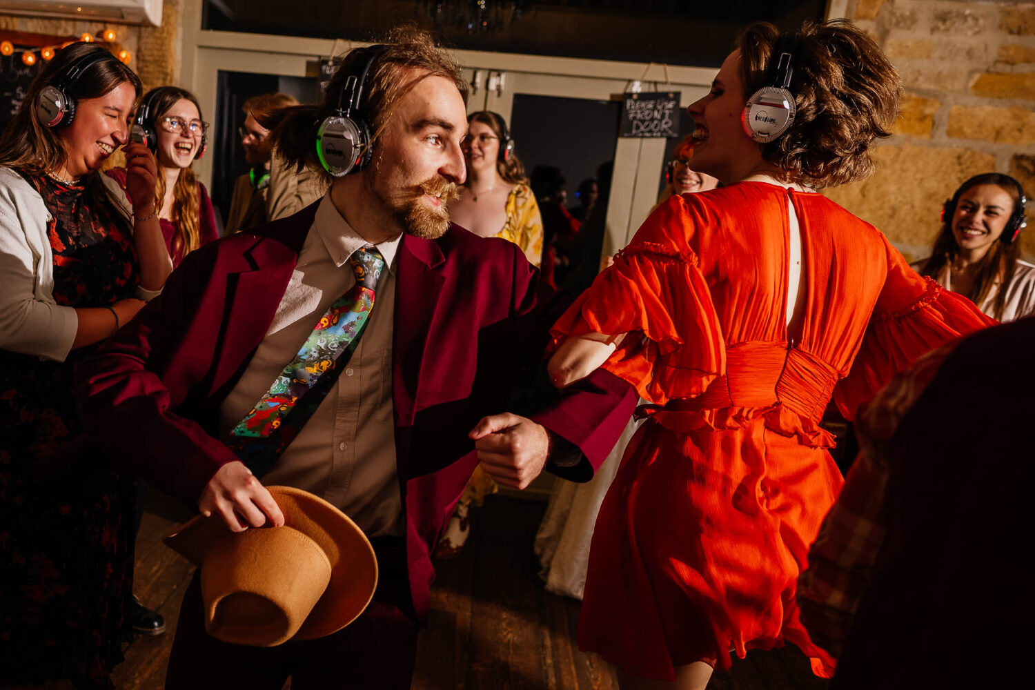 People dancing with linked arms at a headphone disco