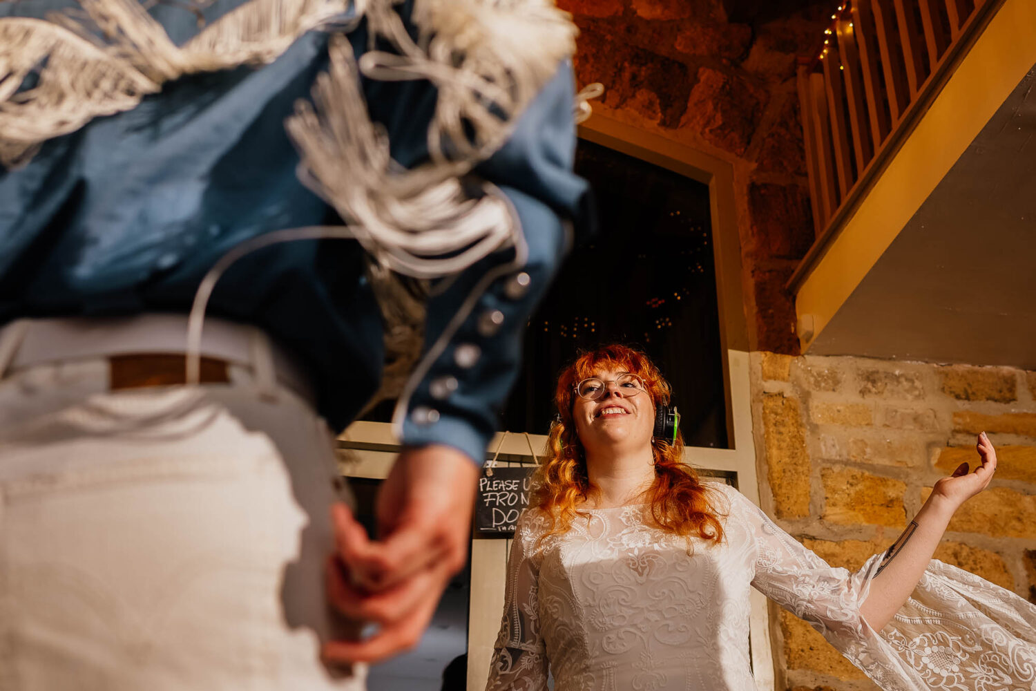 Bride dancing with fringe cowboy shirt in foreground