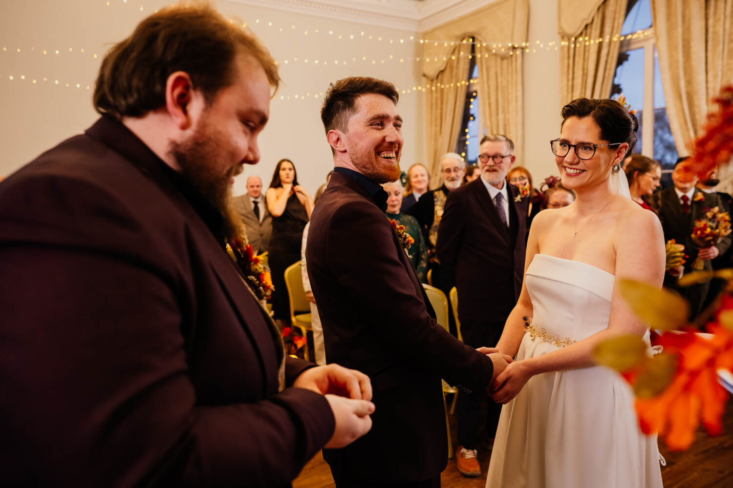 Couple laughing whilst best man passes rings