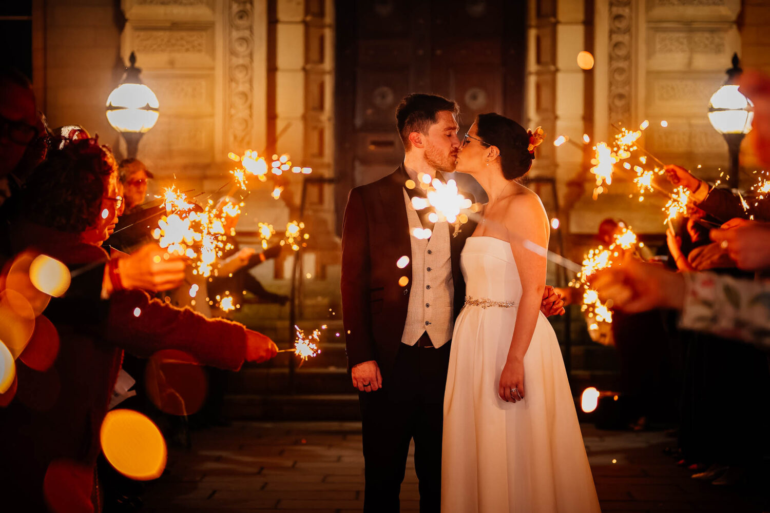 Couple kissing during sparkler exit