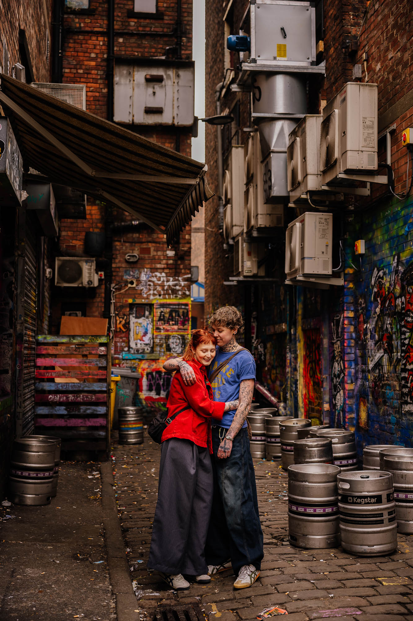 Couple hugging in urban alleyway in Manchester's Northern Quarter