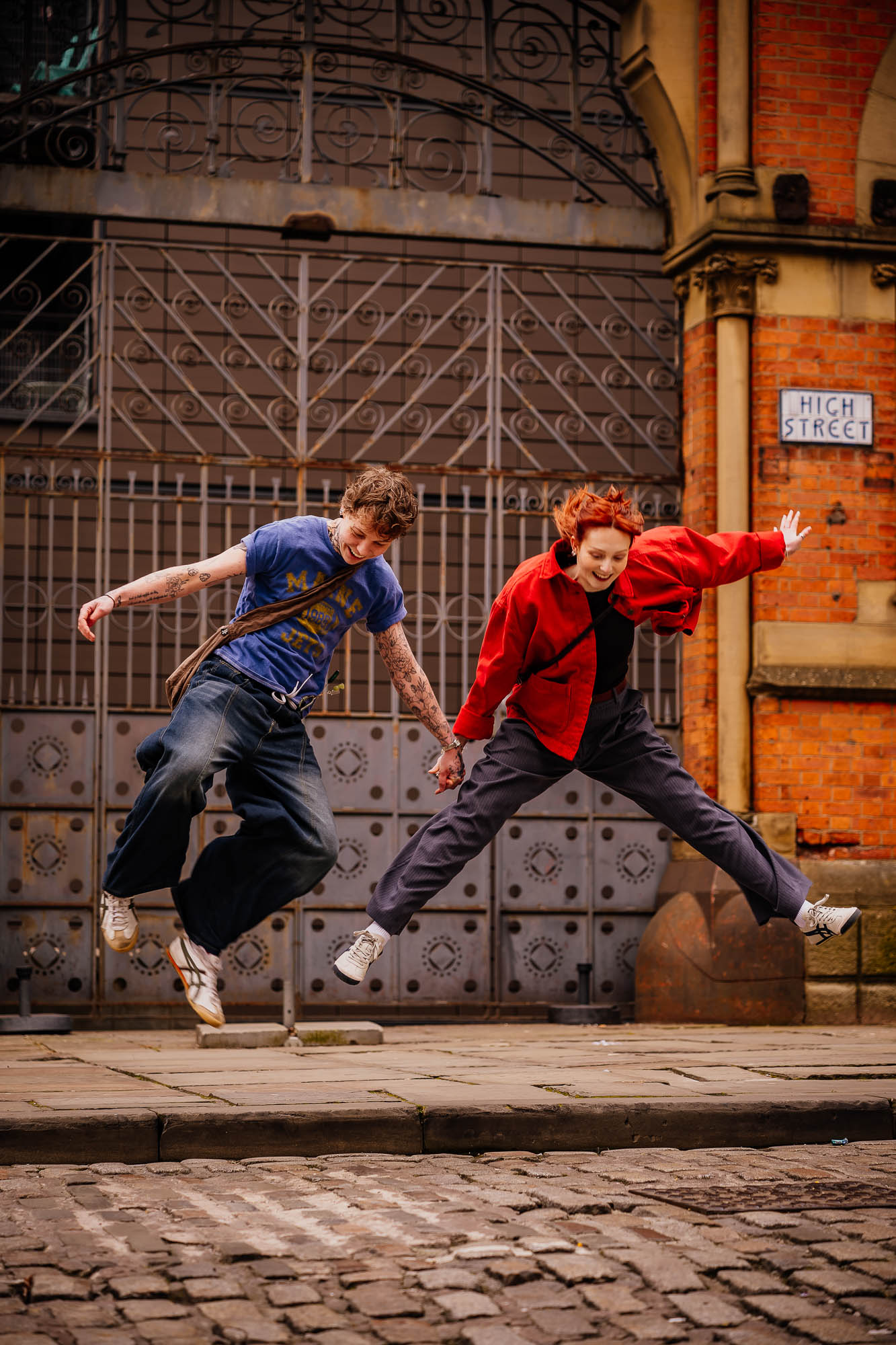 Couple jumping in the air on Northern Quarter High Street