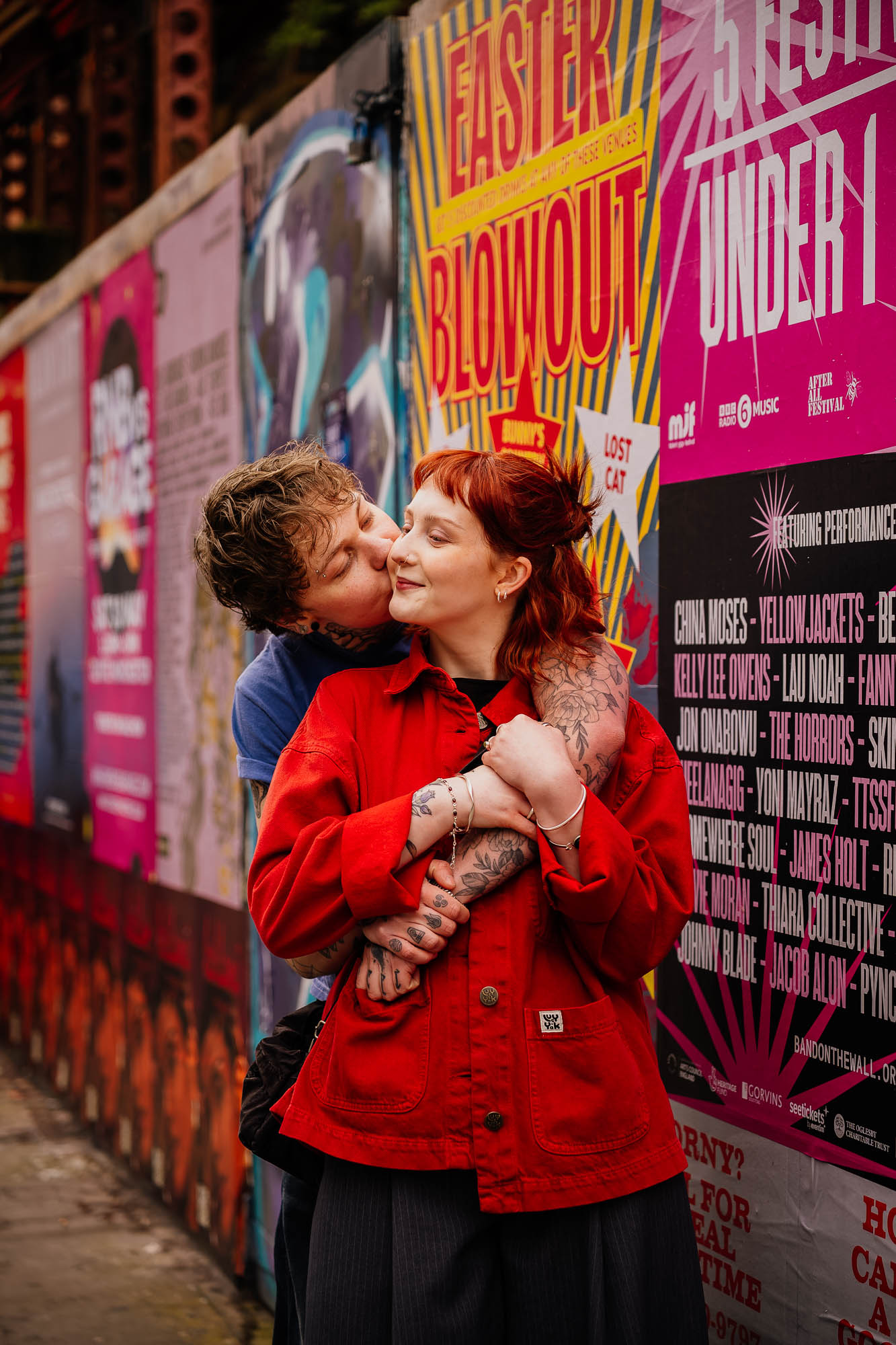 Couple hugging on Thomas Street with posters behind