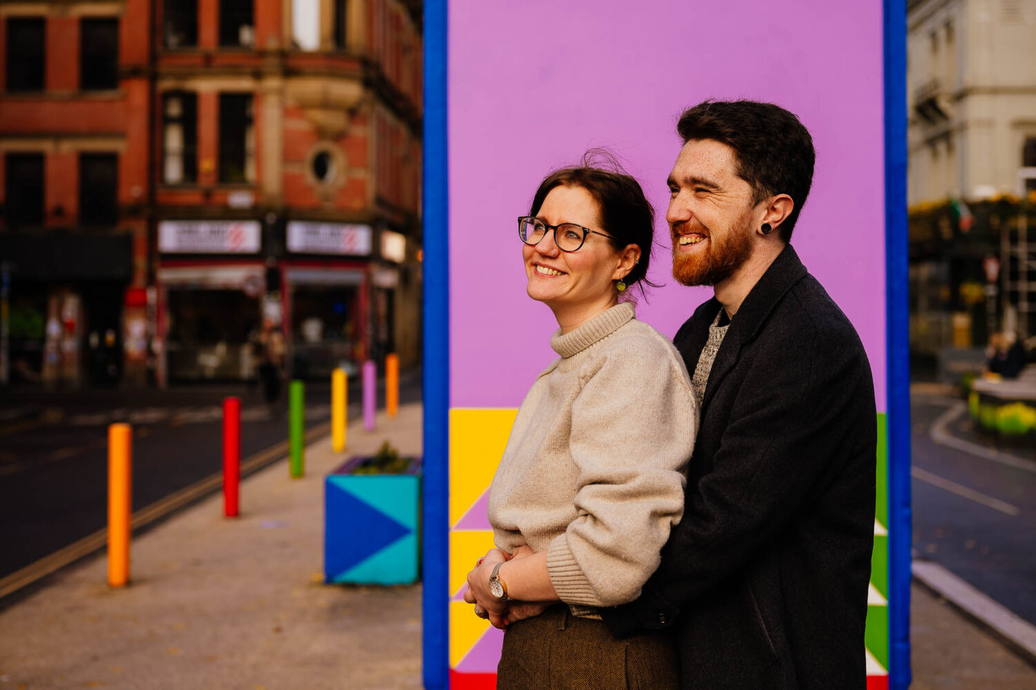Couple hugging in front of Stevenson Square mural