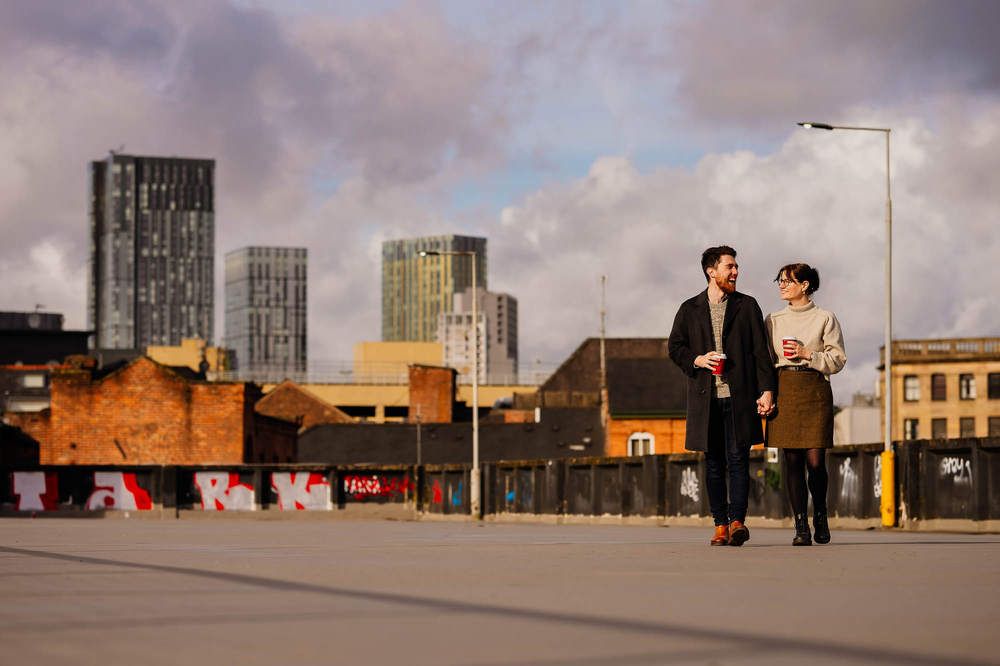 Couple holding hands on the roof of Northern Quarter multi-storey car park