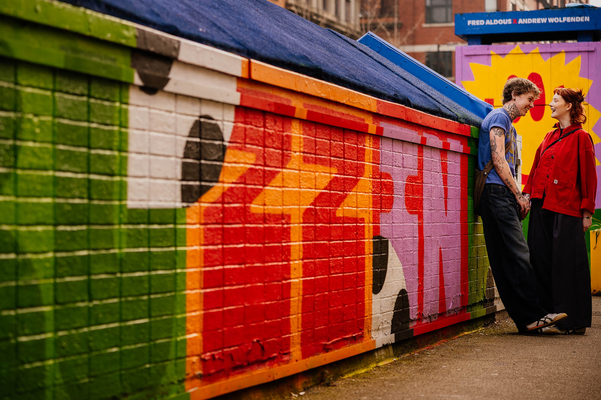 Couple at Fred Aldous mural in the Northern Quarter