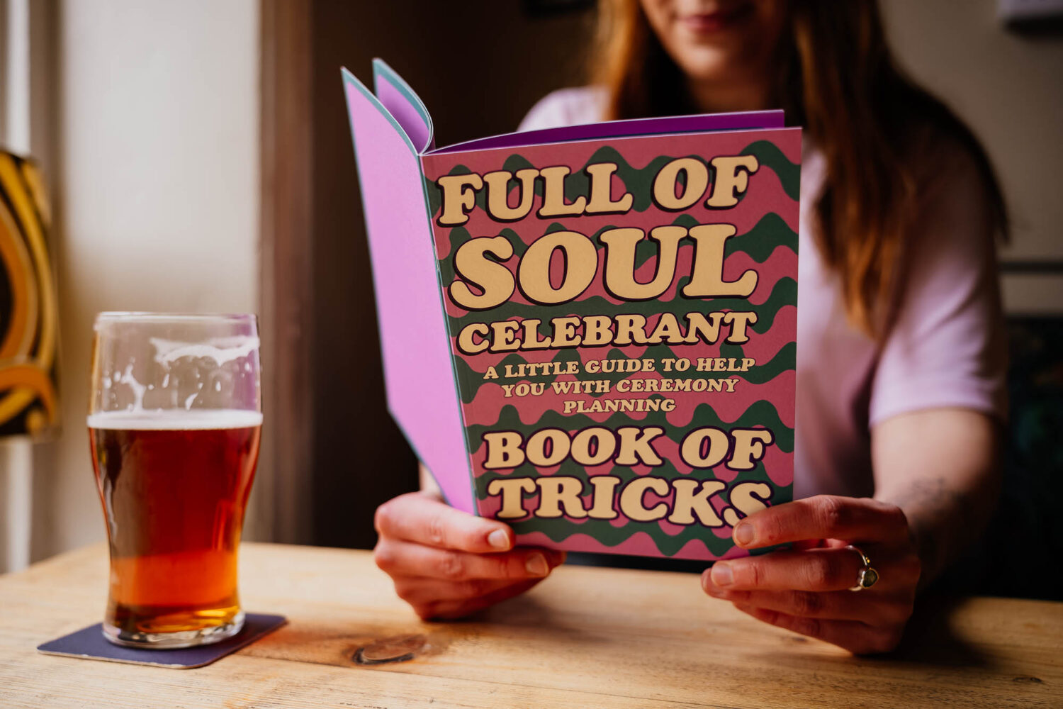 Woman holding a booklet for her business with a beer