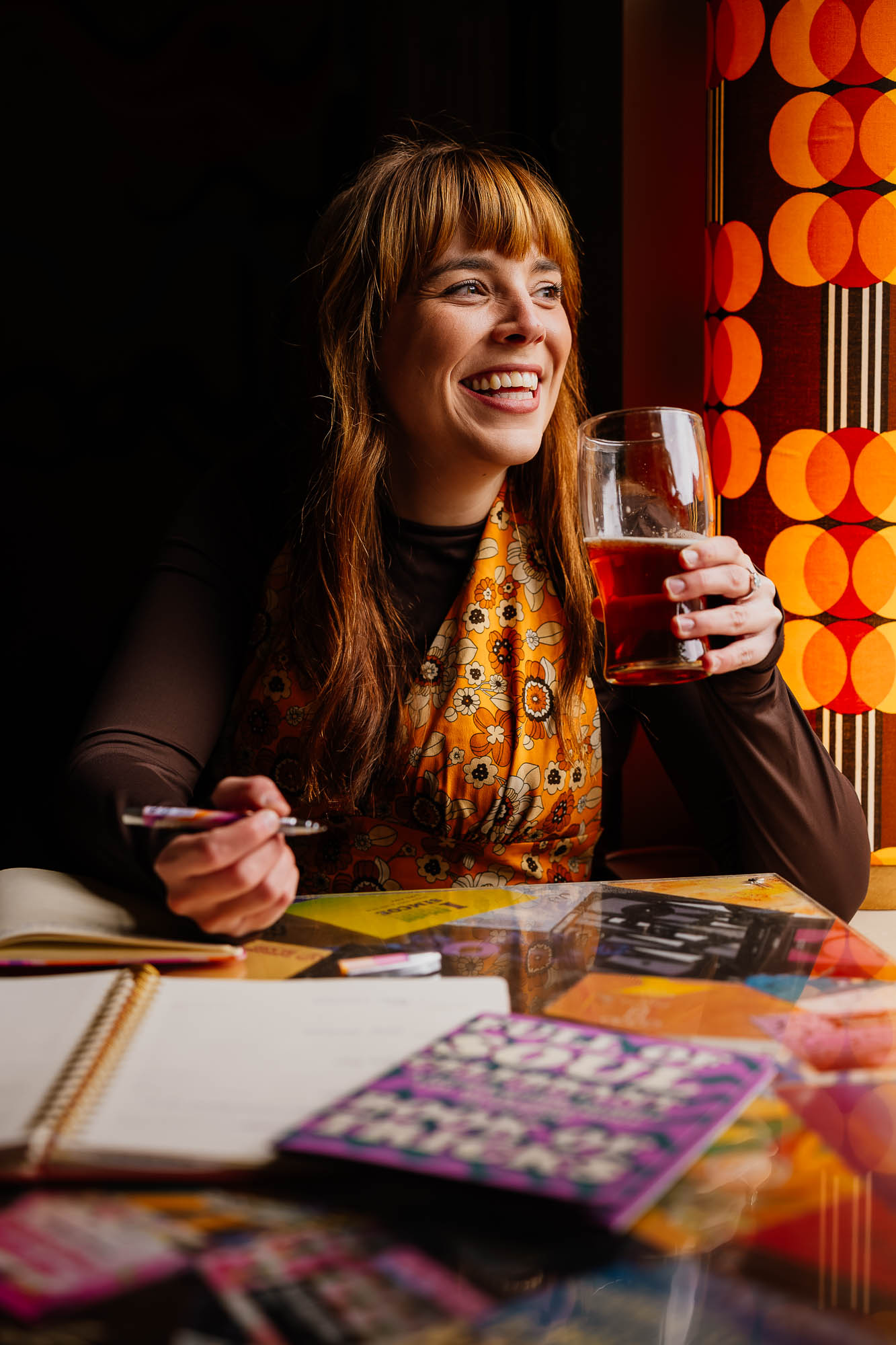 Woman wearing retro patterns drinking beer and working