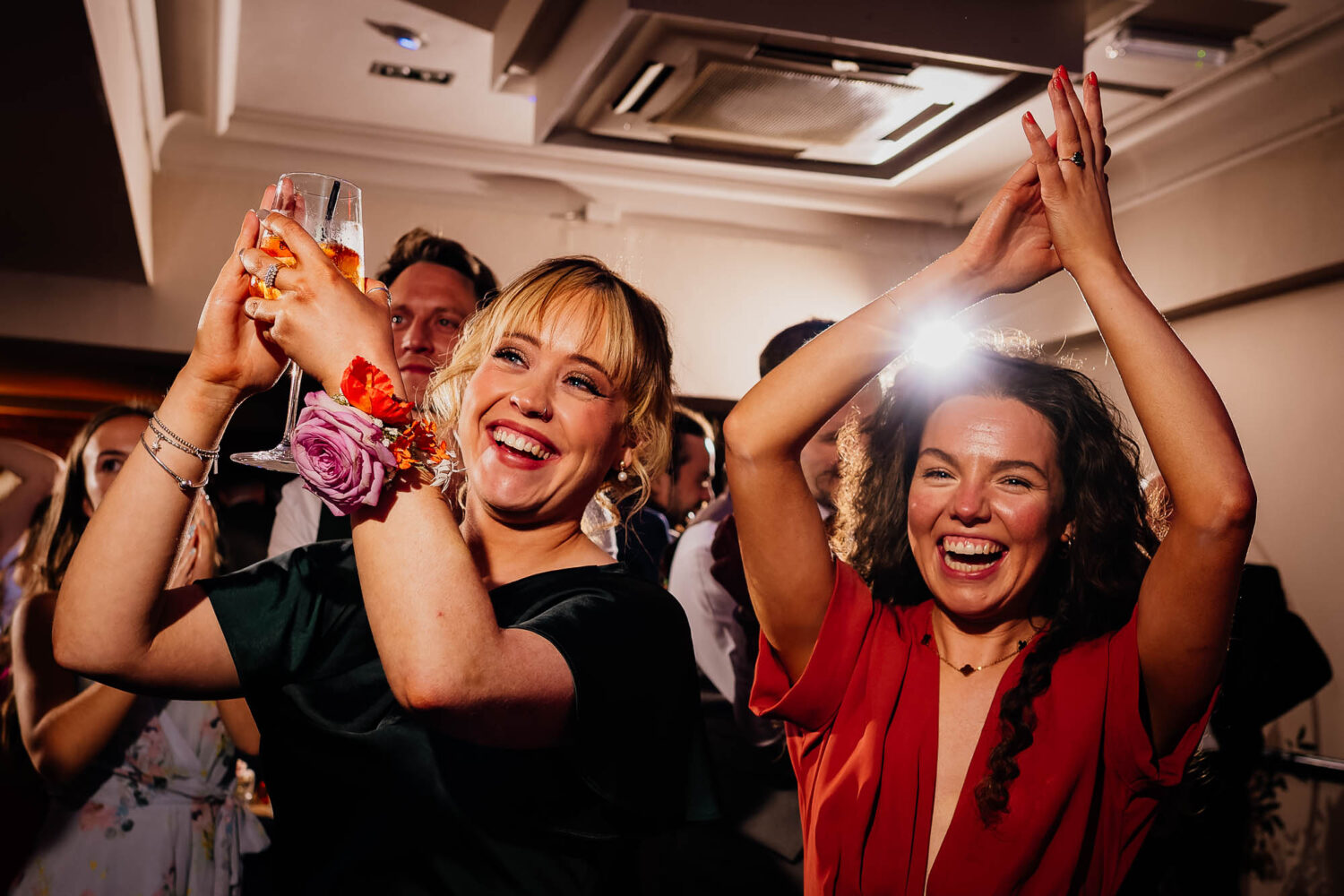 Bridesmaids raising glasses and clapping