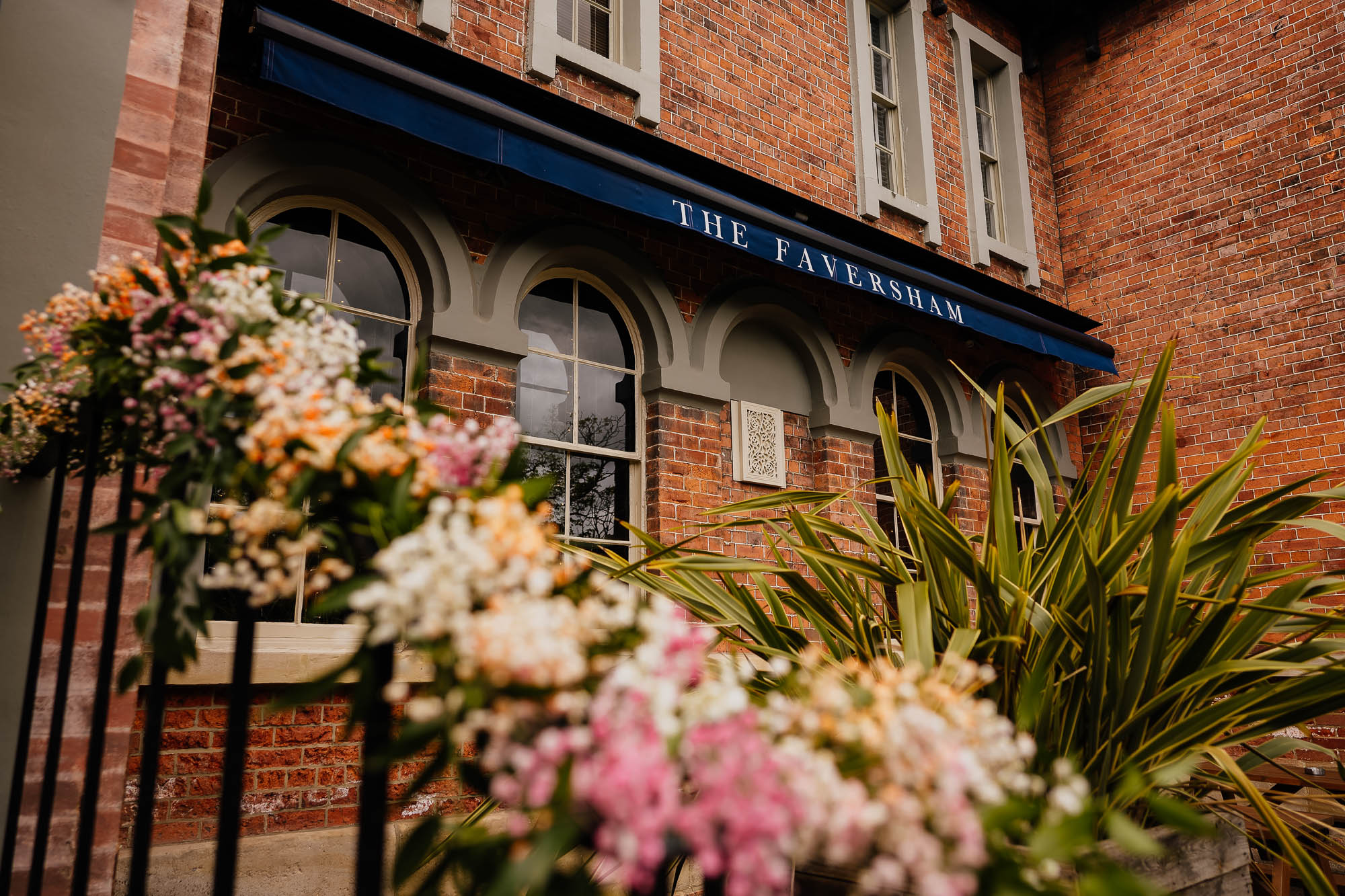 Outside The Faversham in Leeds with flowers on the railings