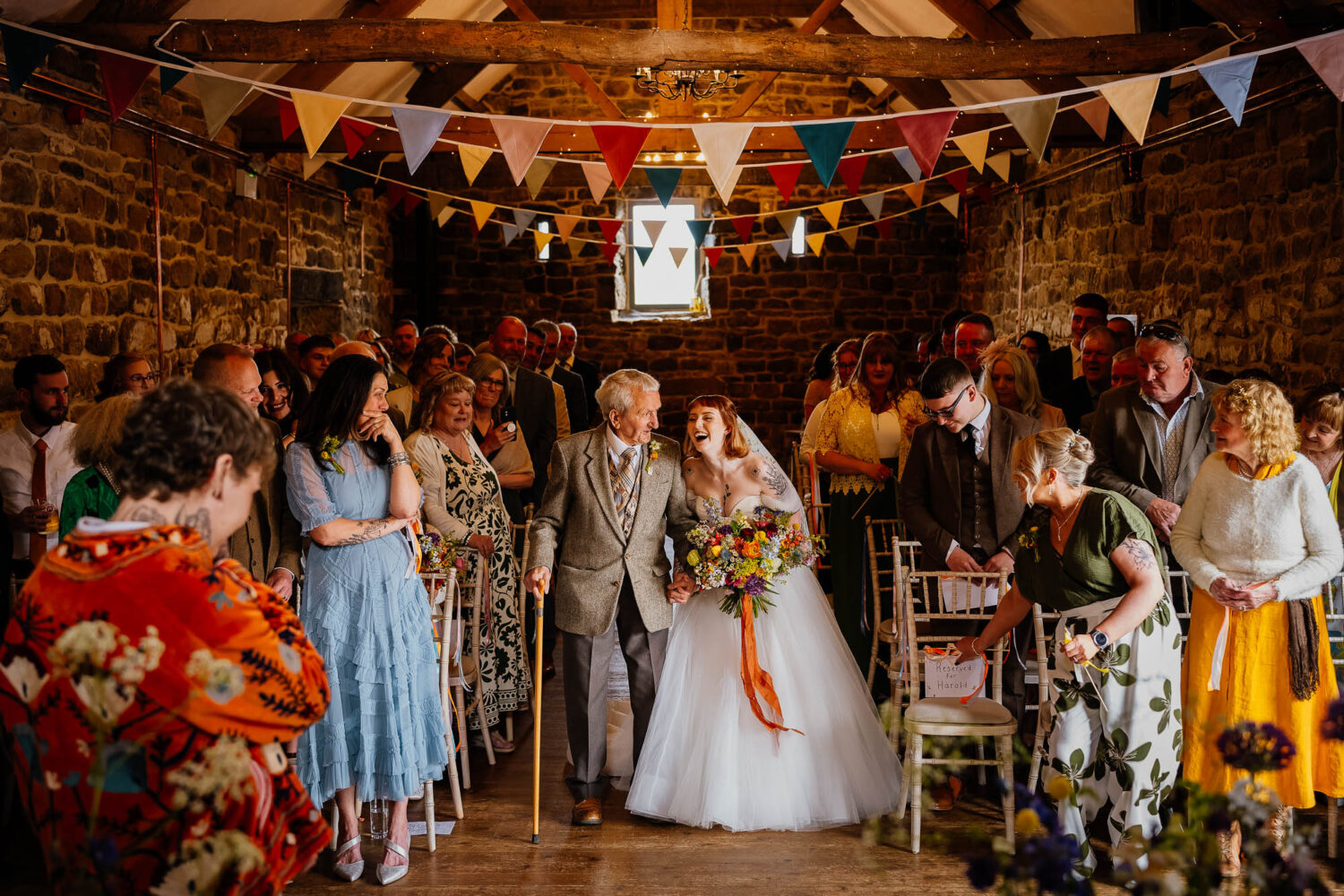 Bride and grandad walking down the aisle at Danby Castle Barn wedding