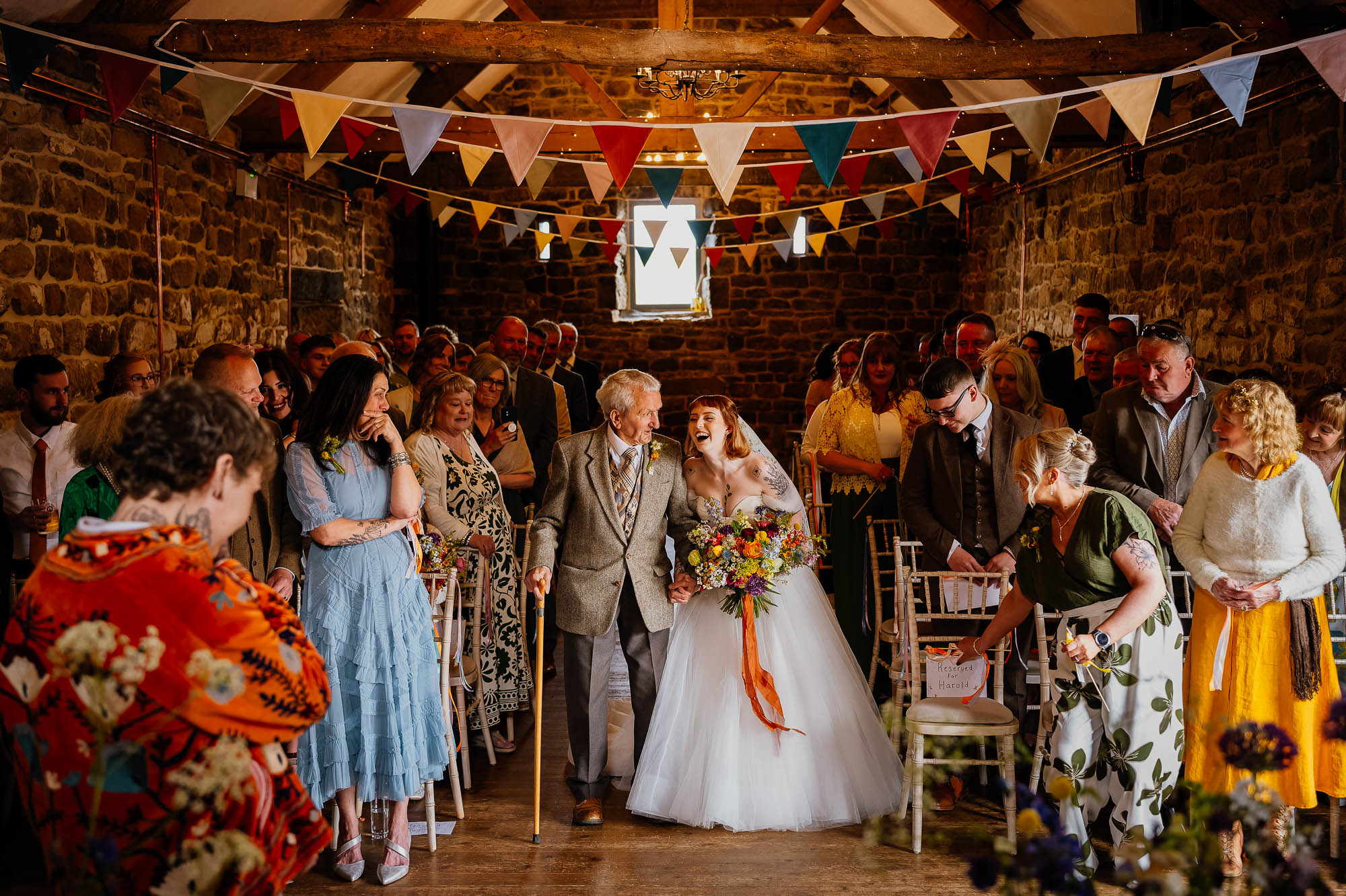 Bride and grandad walking down the aisle at Danby Castle Barn wedding
