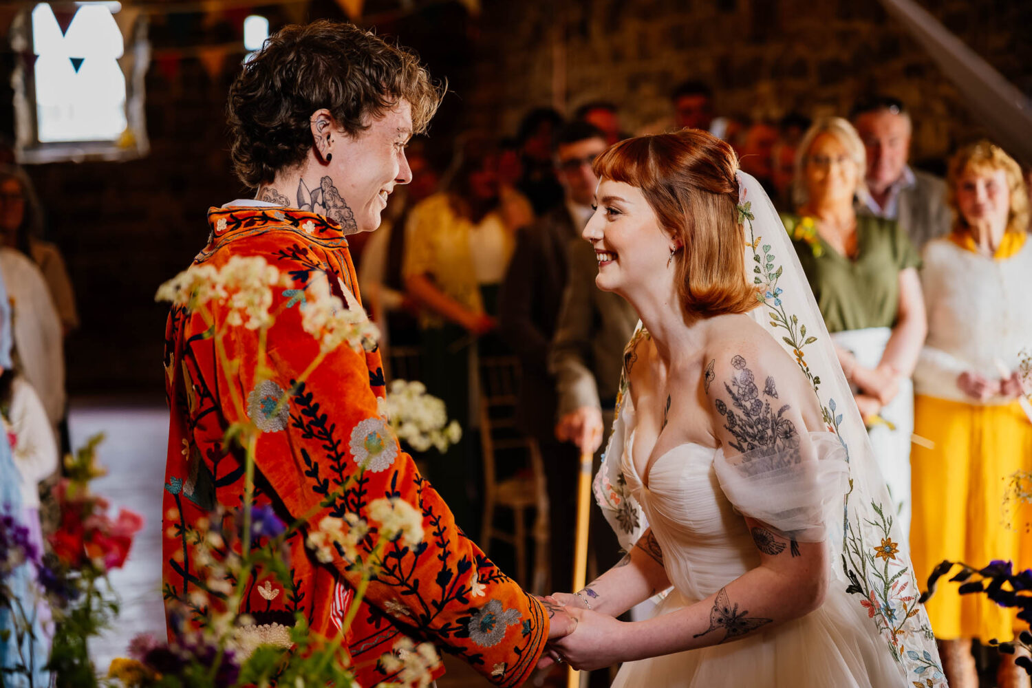 Couple holding hands and smiling during wedding ceremony