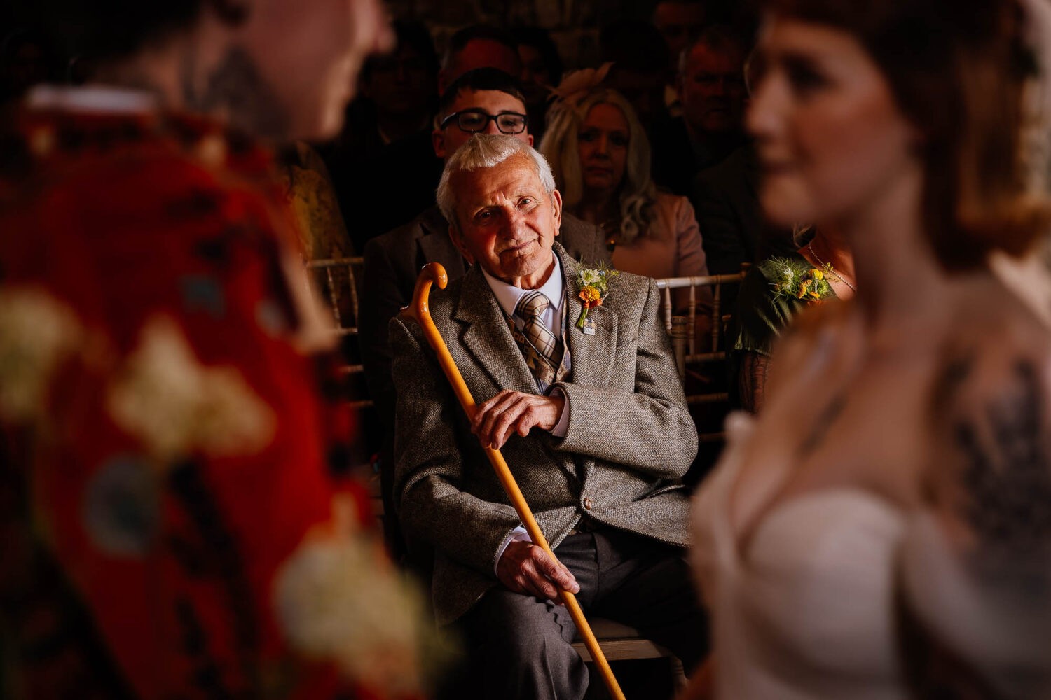 Grandad watching ceremony and smiling whilst holding his walking stick