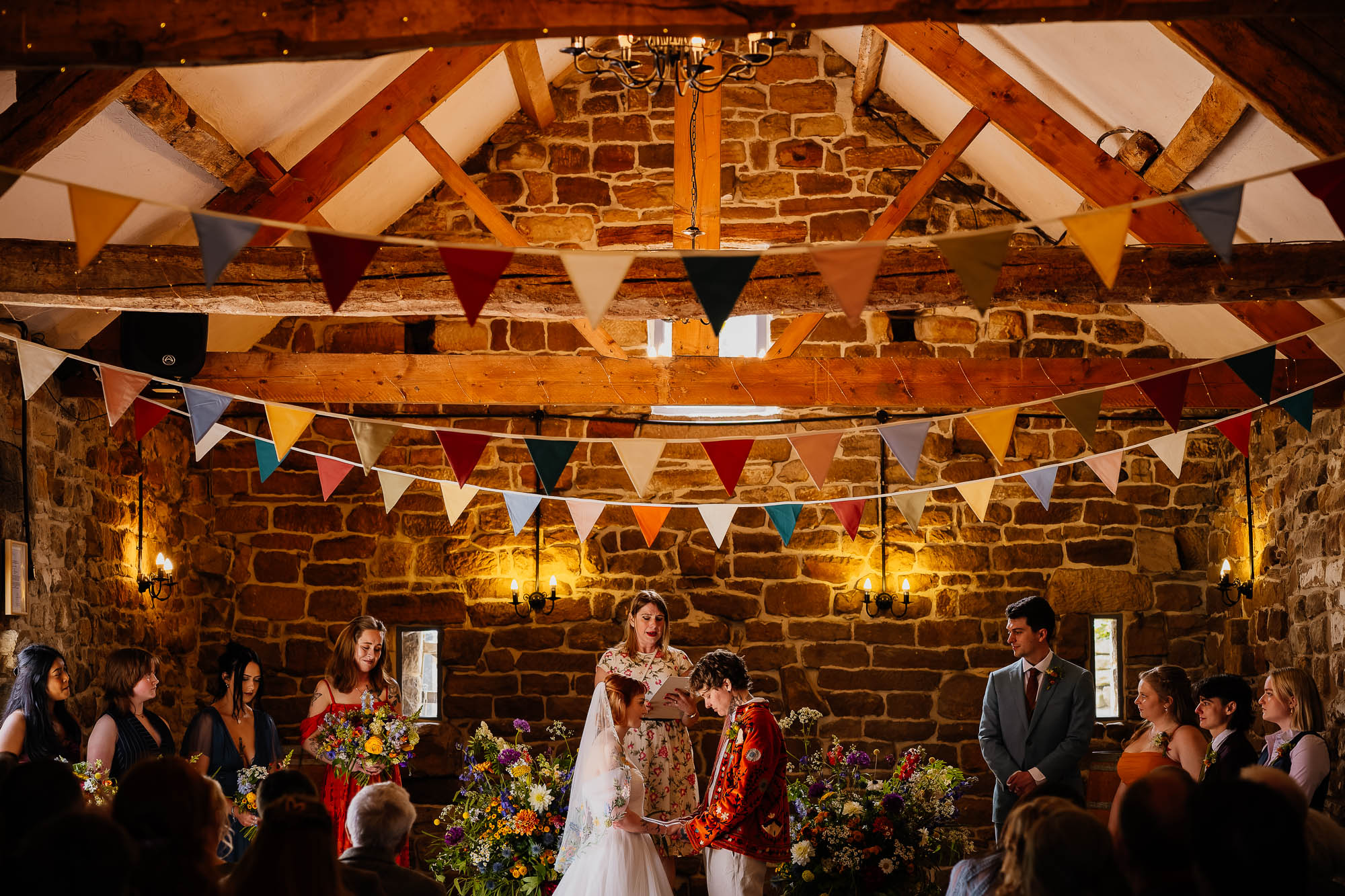 Ceremony at Danby Castle Barn with wedding party stood either side