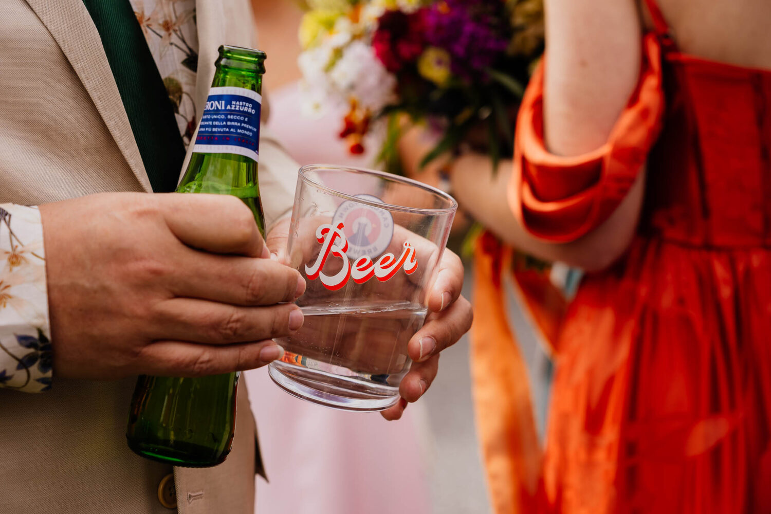 Hands holding beer bottle and beer glass with water in