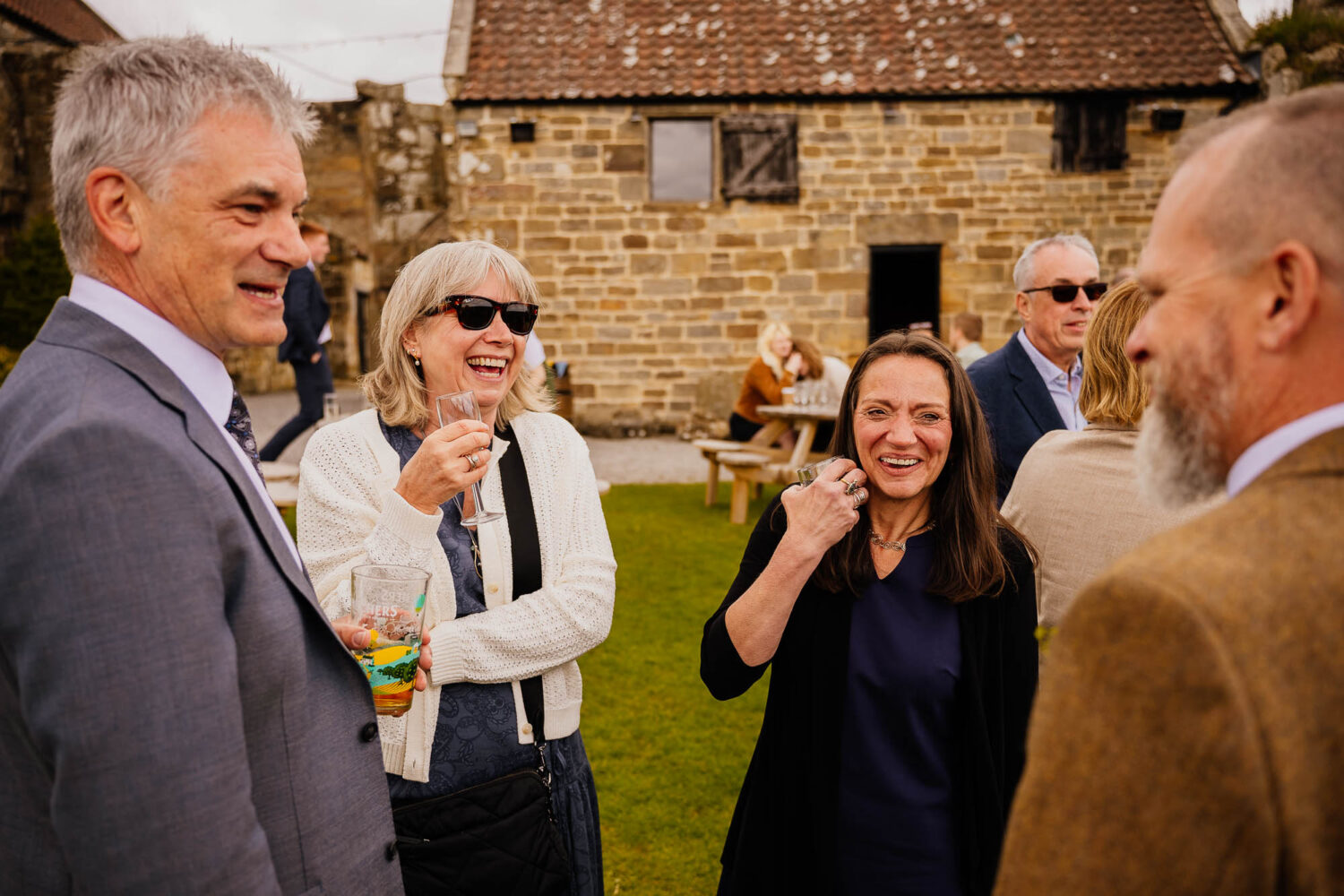 Family stood chatting and laughing with drinks in hand