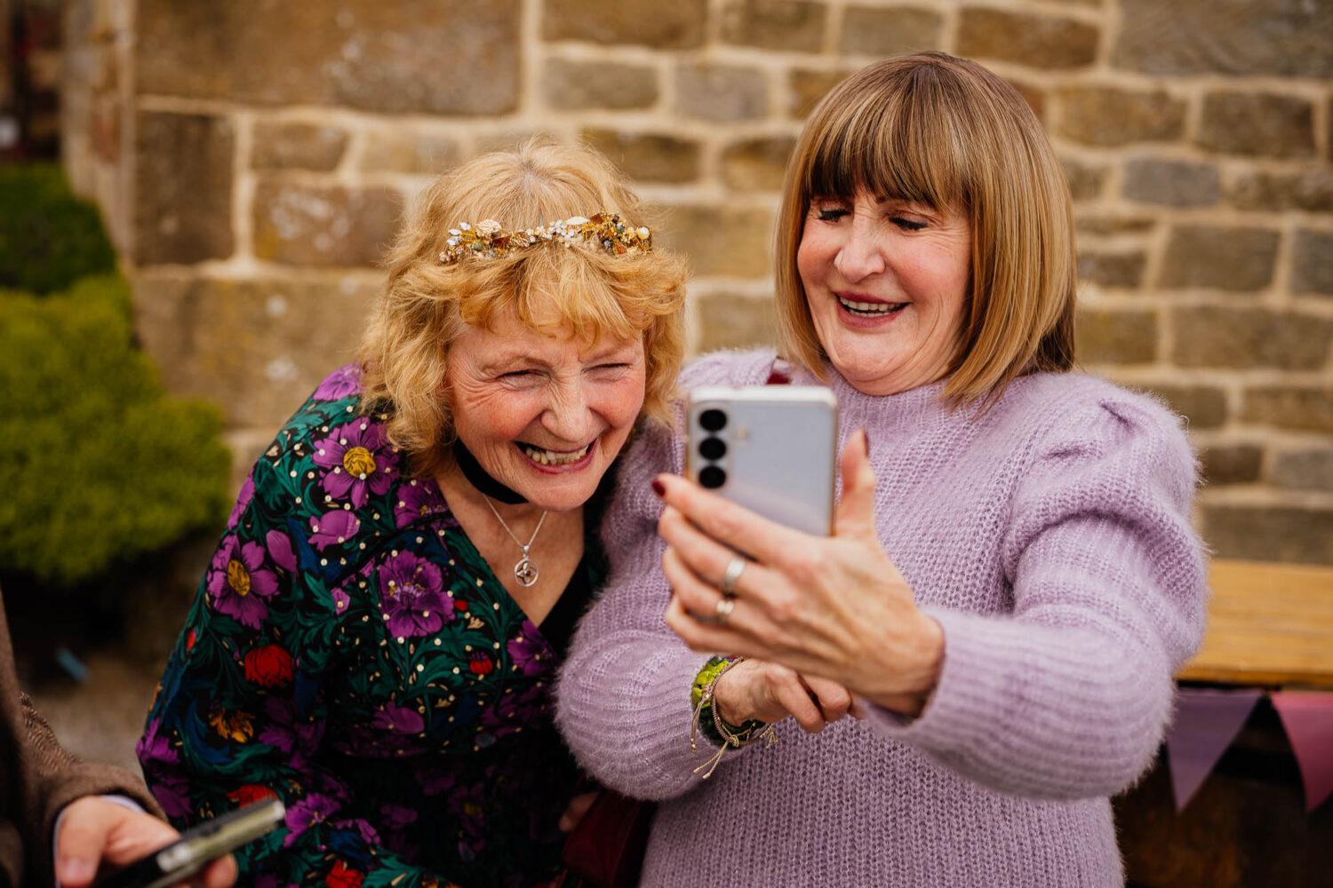 Two women laughing whilst looking at photo