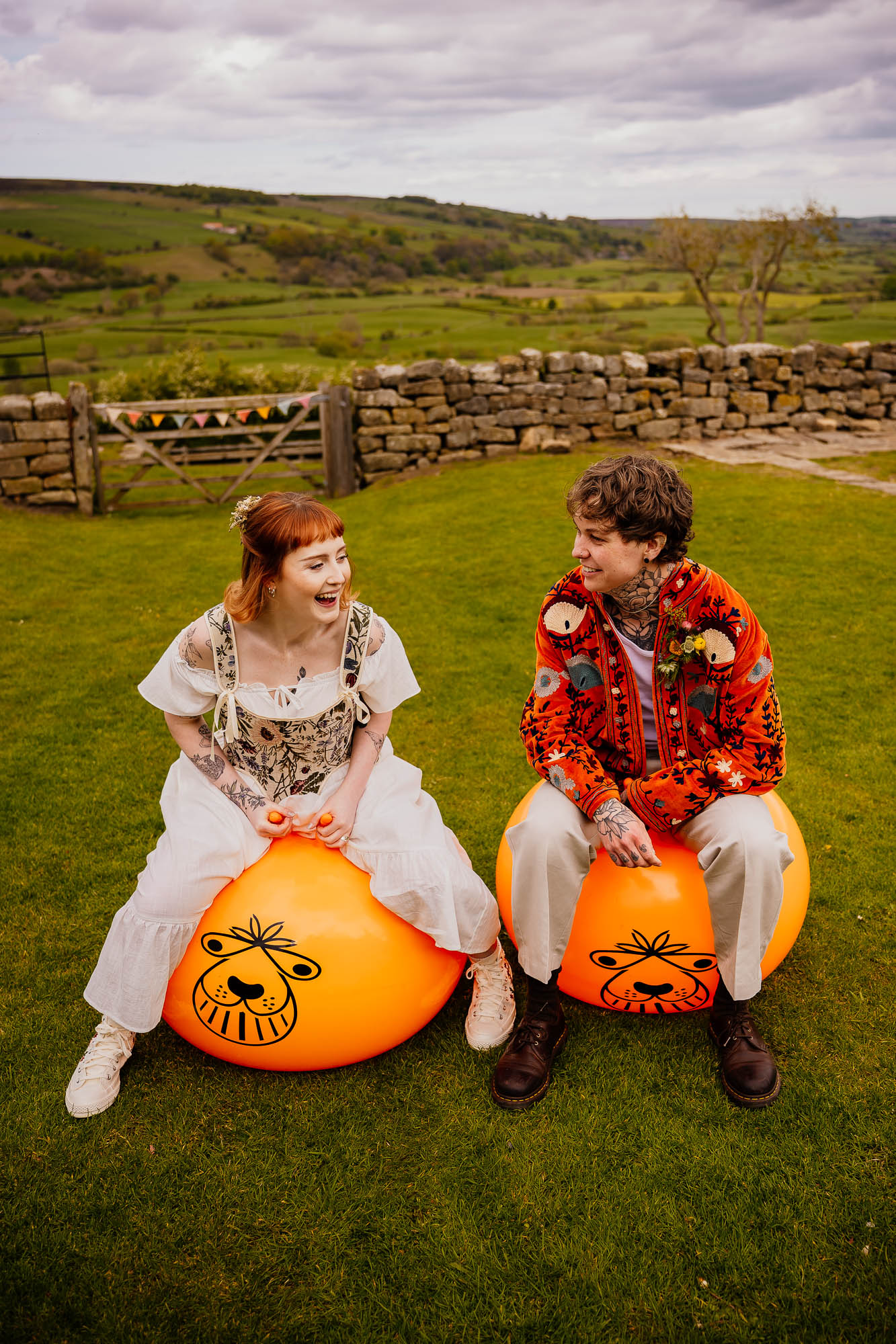 Couple portraits on space hopper with view from Danby Castle behind