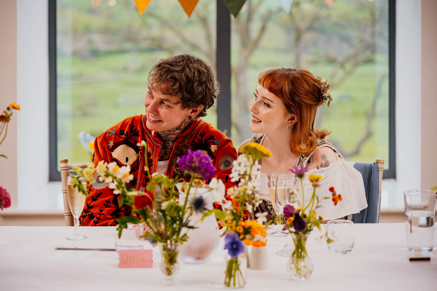 Couple sat at Sweetheart table surrounding by flowers at Danby Castle