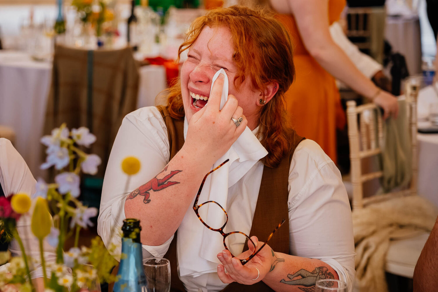 Person wiping tears away with napkin whilst laughing