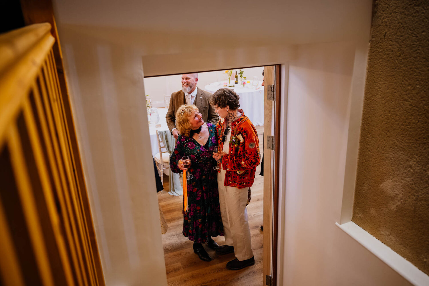 Groom hugging guest through a doorway