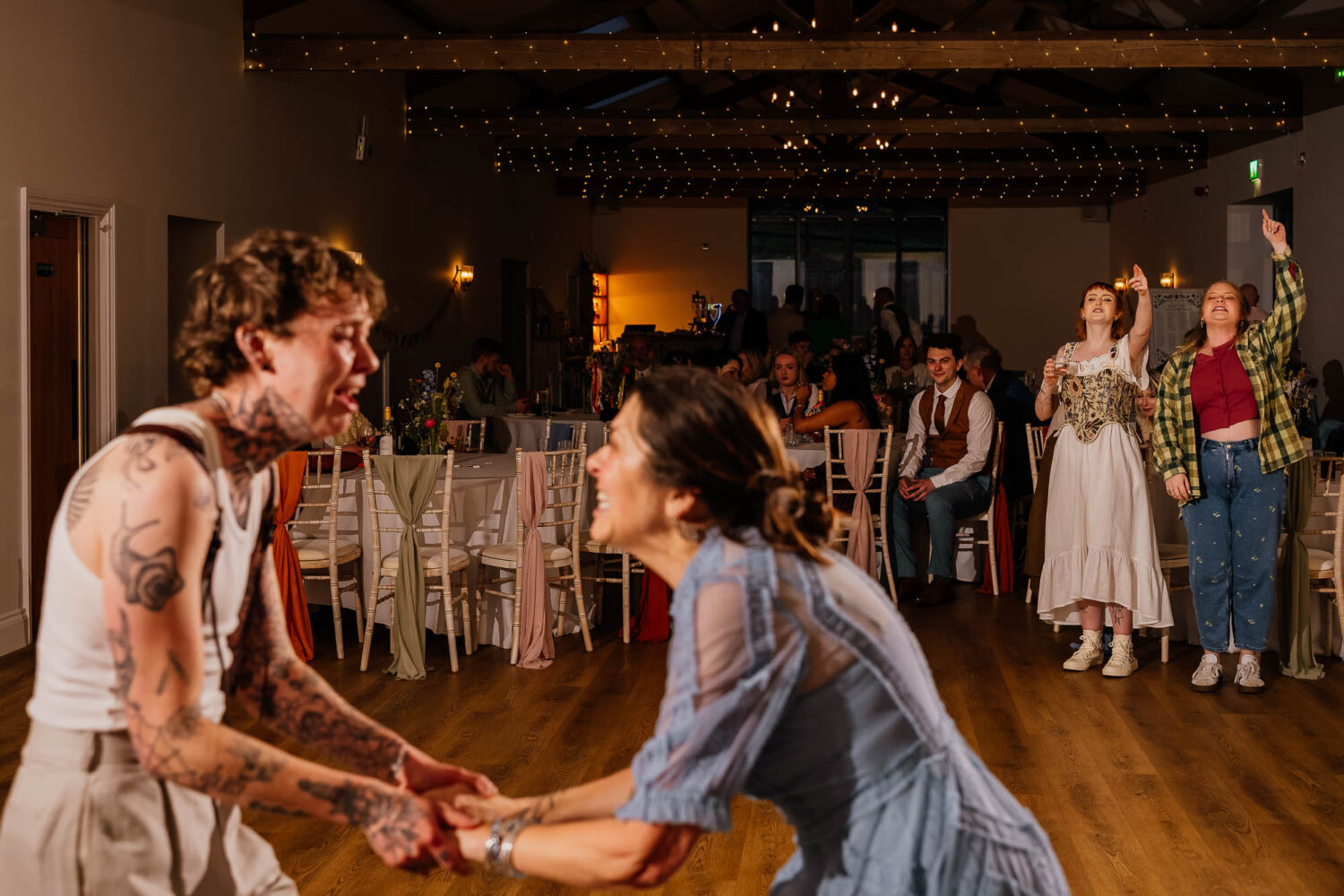 Groom dancing with mum whilst people watch and cheer them on
