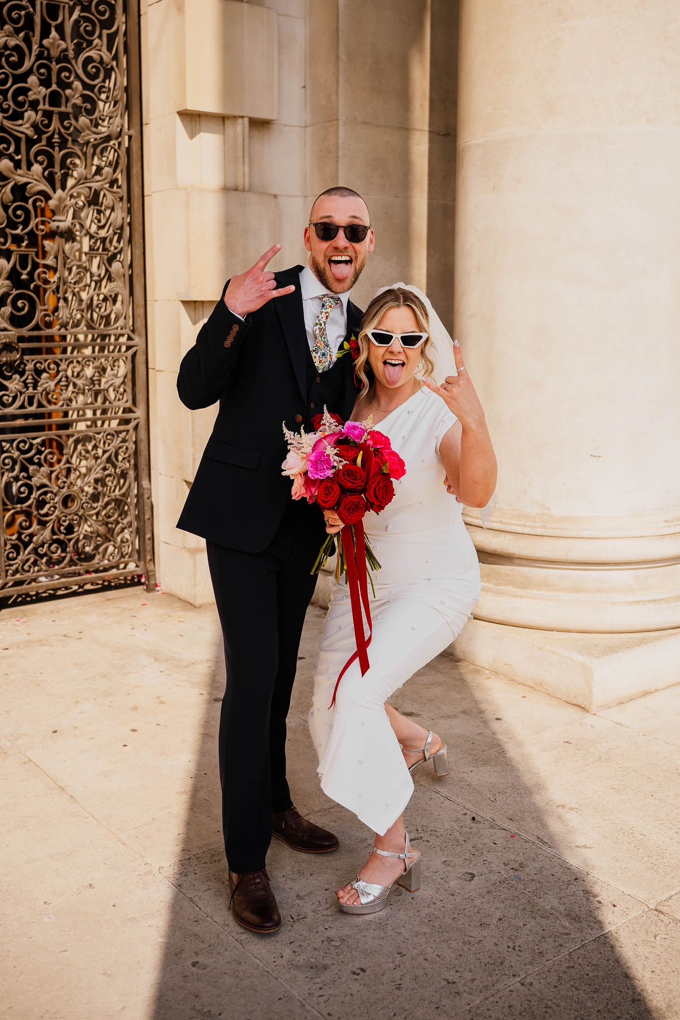 Couple portrait with tongues out gesturing at Leeds Civic Hall