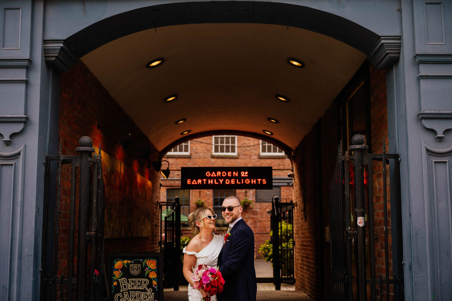 Couple stood under blue arch at The Nation of Shopkeepers in Leeds
