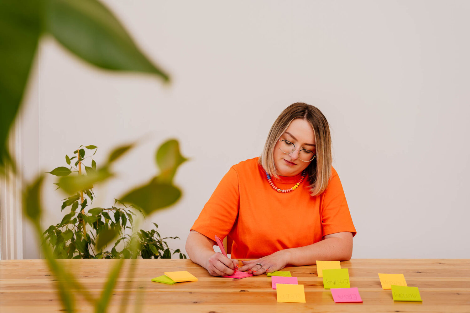 Woman sat at desk writing out post-it notes