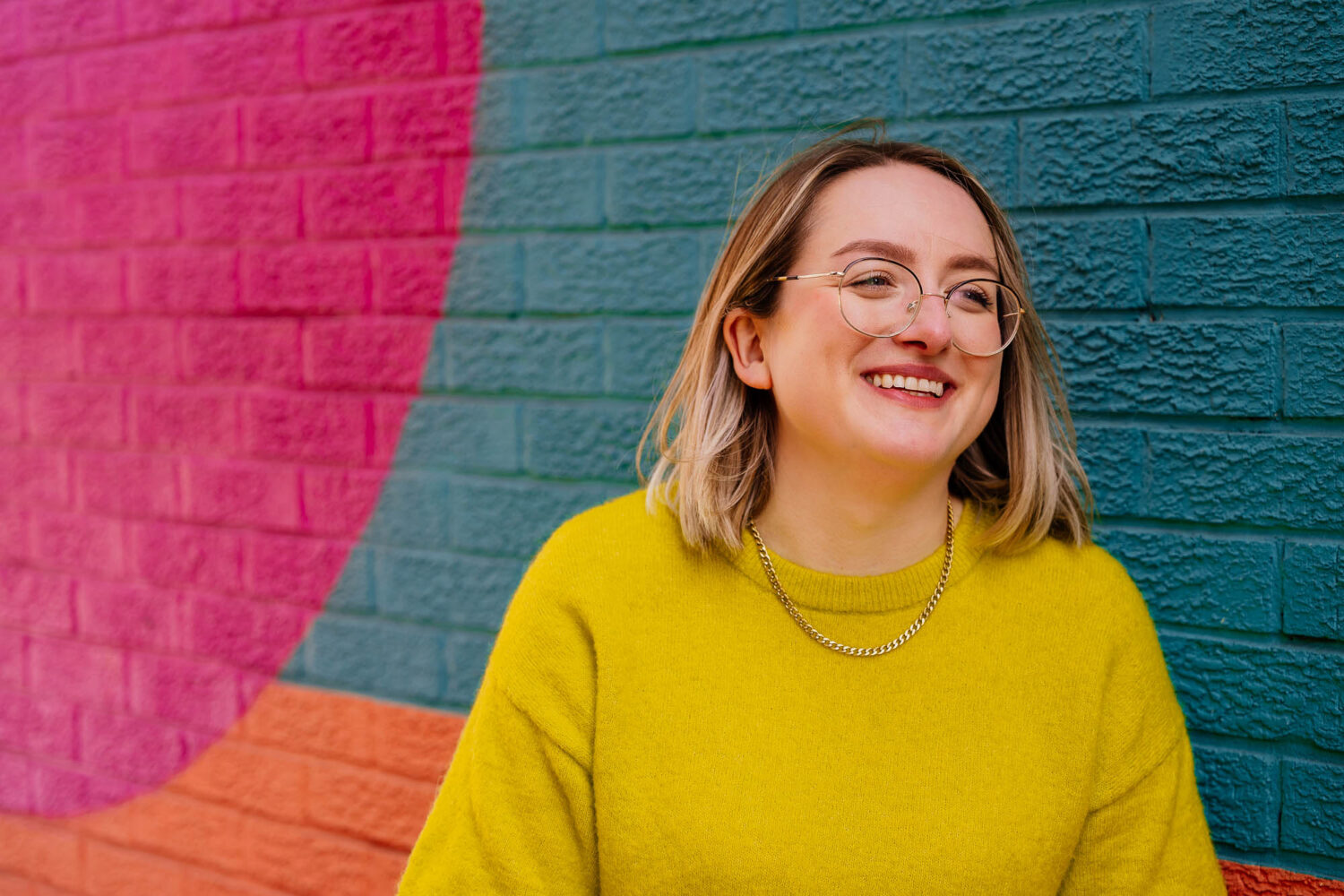 Portrait of woman against colourful mural in Leeds