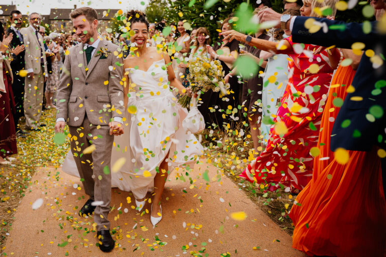 Bride and groom walking through yellow and green paper confetti