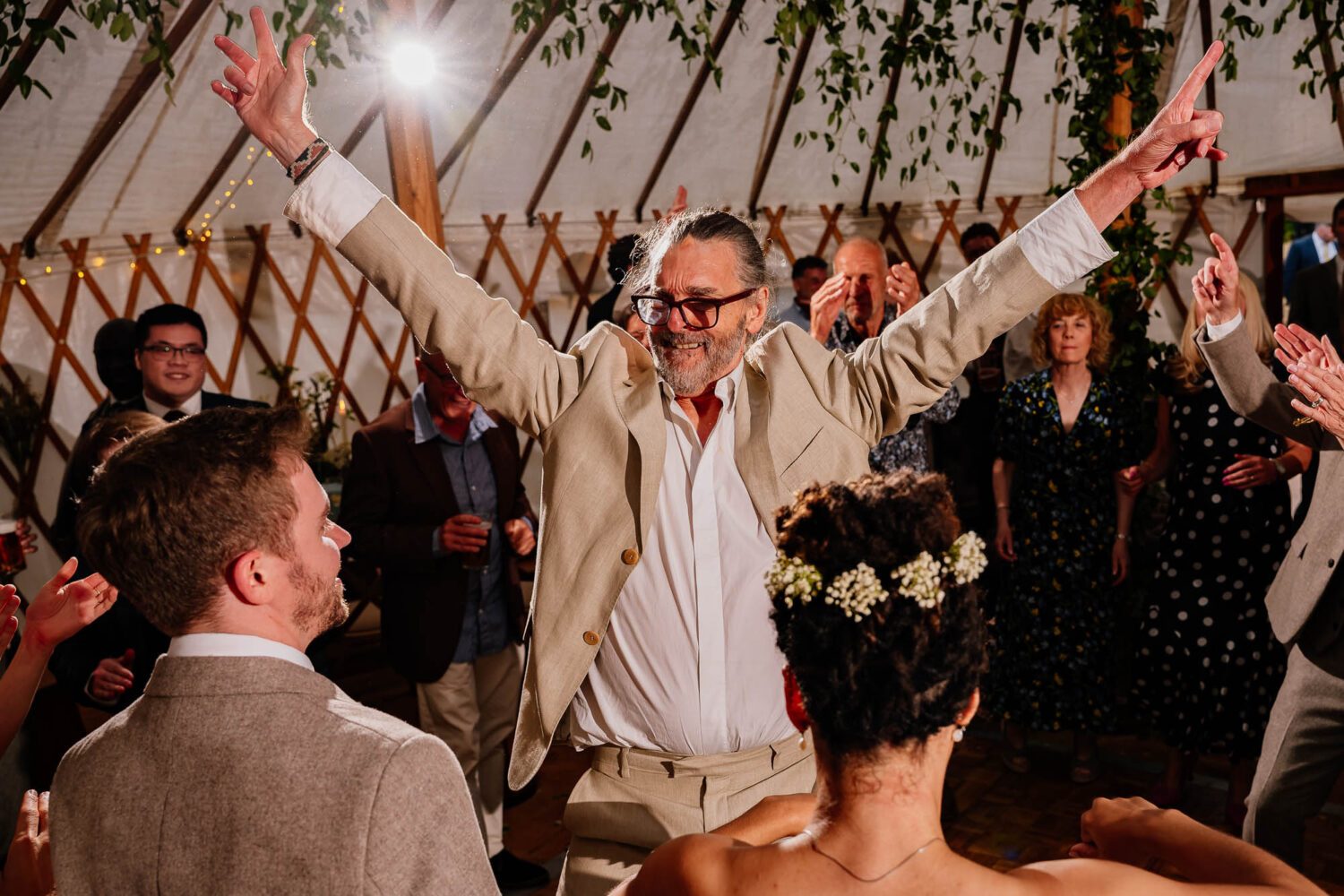 Guest with raised arms on the yurt dancefloor