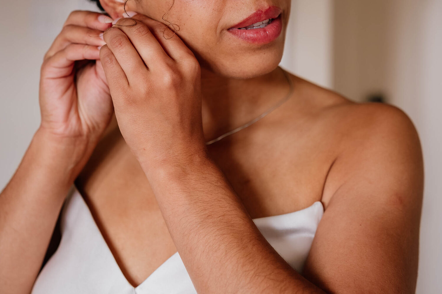 Close up of bride's face putting earrings in