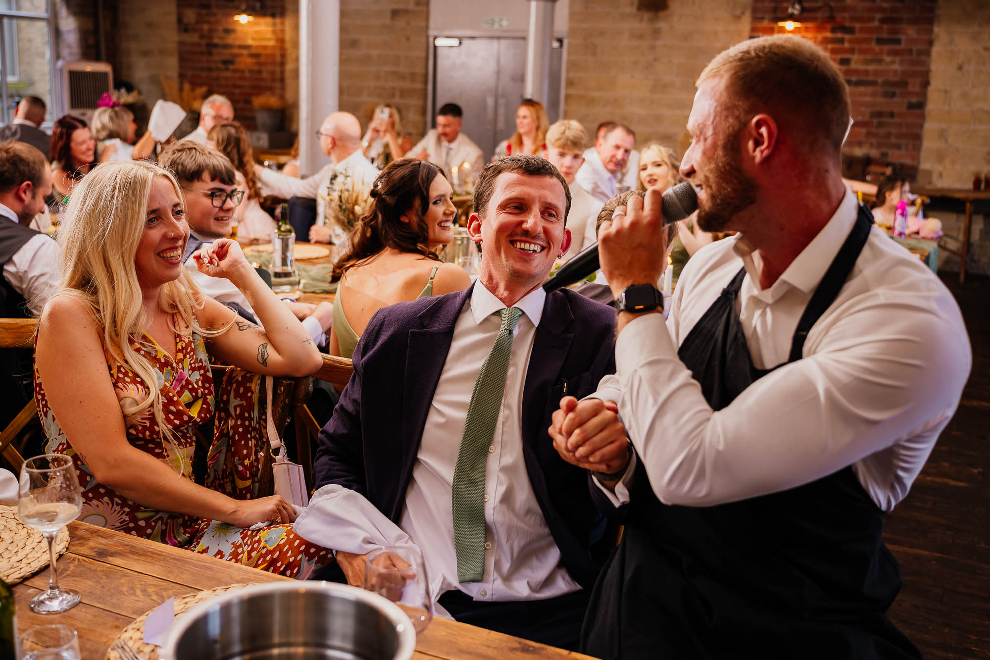 Singing waiter sat with guests during wedding breakfast at The Spinning Room